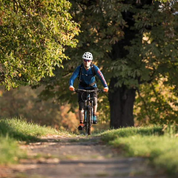 Eine Radfahrerin fährt einen Feldweg entlang